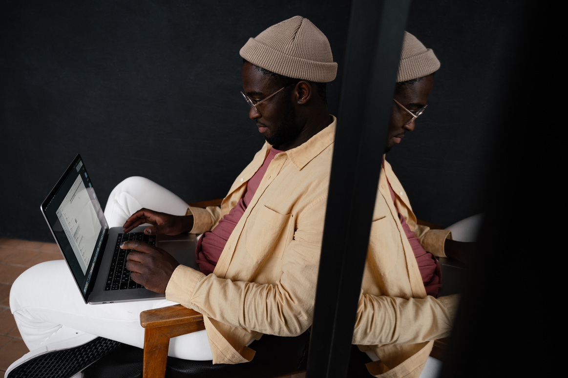 Focused black man typing on laptop